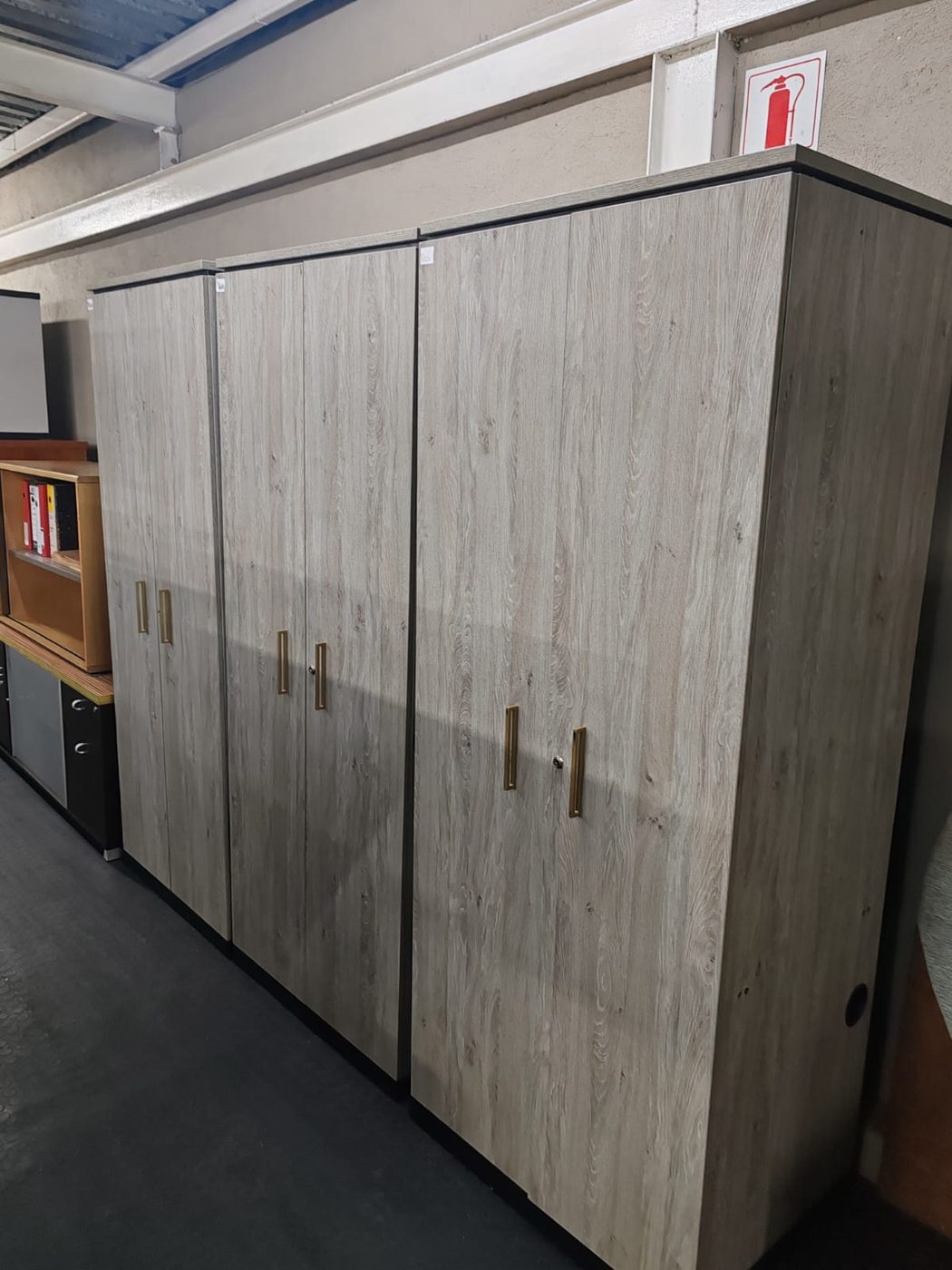 Second-hand grey oak double-door cupboards with gold handles
